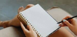 Persona che scrive sul suo quaderno