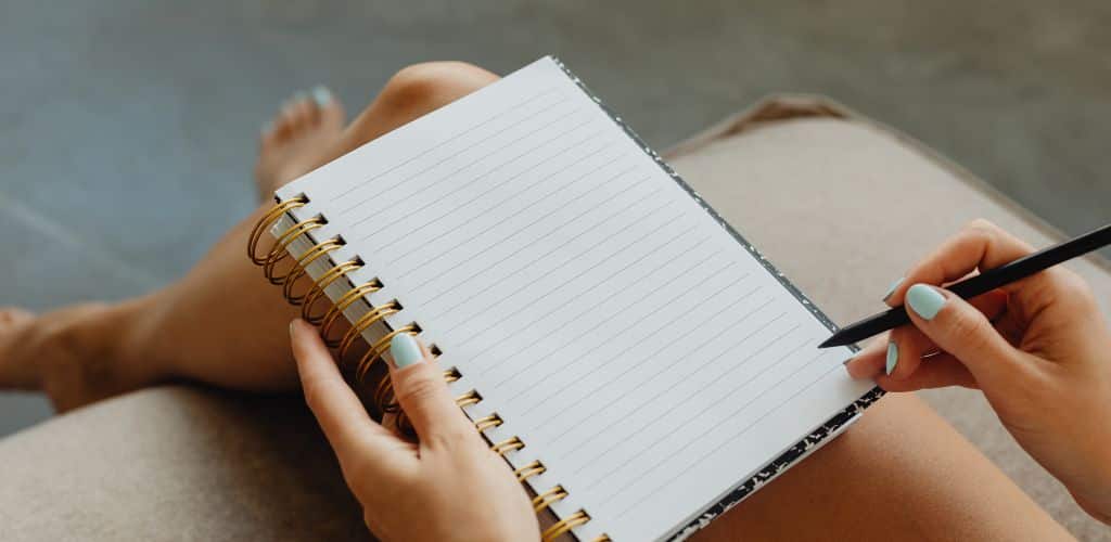 Persona che scrive sul suo quaderno