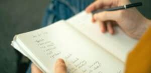 Persona che scrive sul suo quaderno